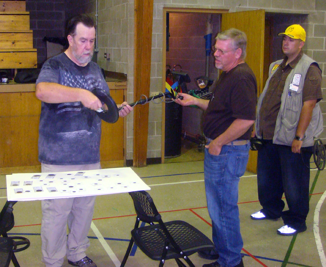 President Jeff Hungerford helping members scan various targets with their detectors.